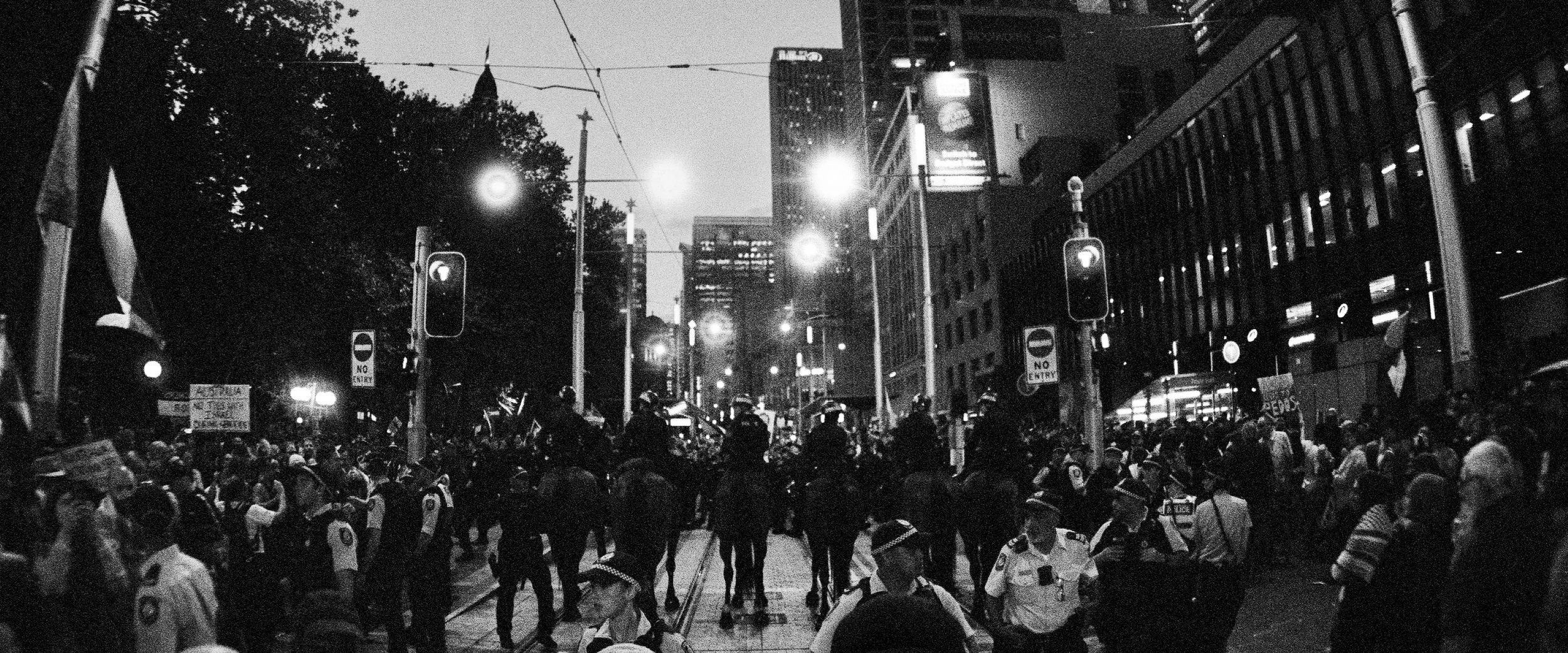 NSW Police officers detaining a protester during a demonstration in Sydney opposing the Australian visit of Israeli President Isaac Herzog — documentary photography by Elliott Deem.