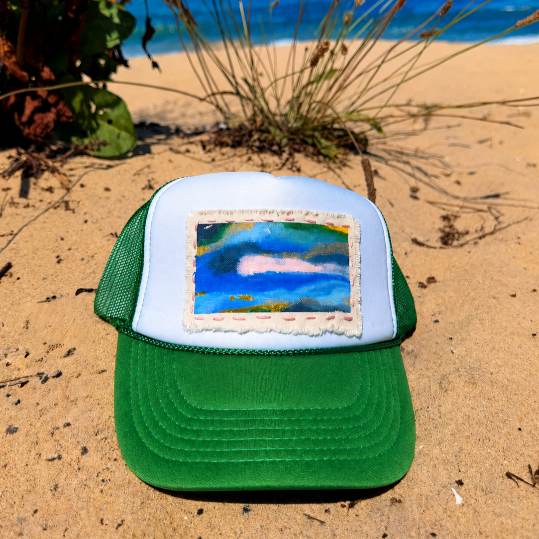 Green and white Beach Mini No. 05 trucker hat with original hand-painted canvas art on a Northern Michigan beach