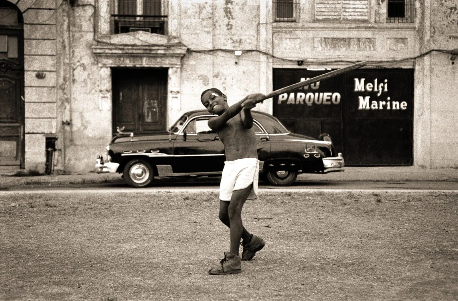 Boy playing baseball on a Havana street, Cuba
