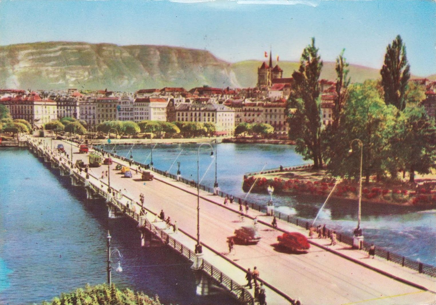 Vintage postcard of Geneva with a view of the Mont Blanc bridge with a few cars and the Salève in the background.