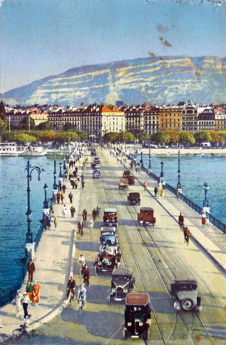 Vintage postcard of Geneva with a view of the Mont Blanc bridge with a few cars and the Salève in the background.