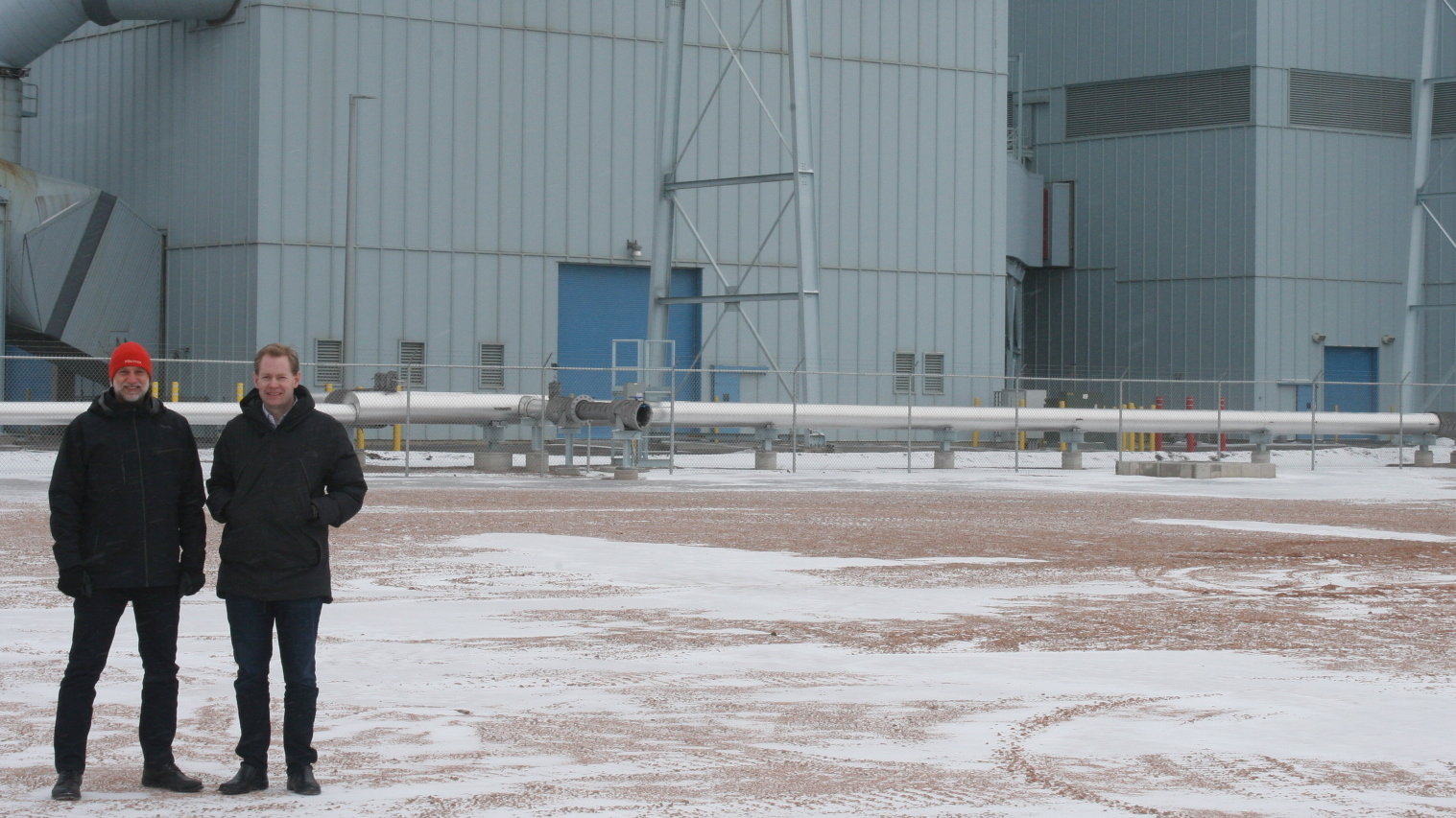 Jason Salfi, left, and Dr. David Erickson, right, of Dimensional Energy, are finalists in the Carbon XPRIZE. They stand in front of the Dry Fork Station coal-fired power plant in Gillette, Wyo., where the competition is located. Cooper McKim/Wyoming Public Radio