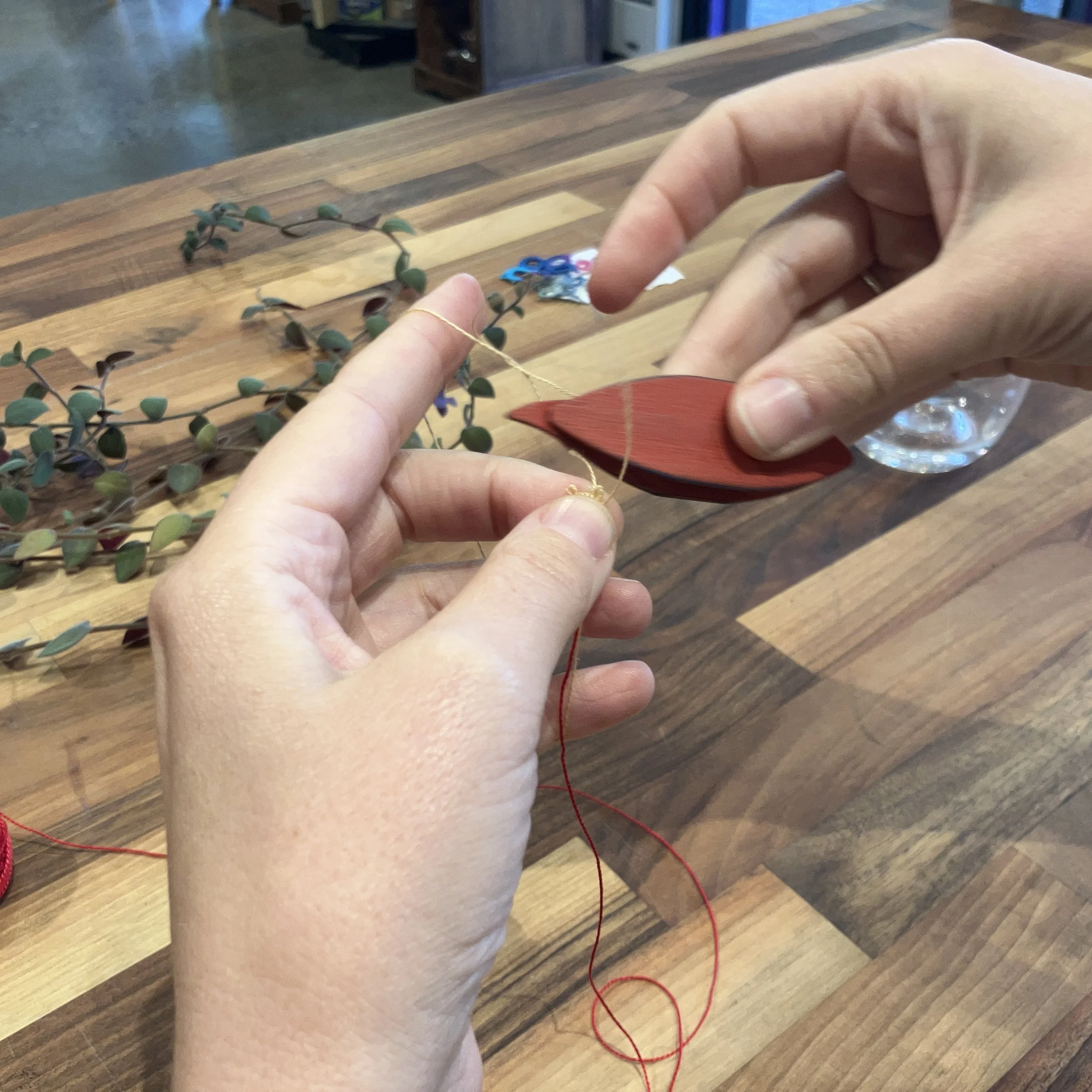 White Woman's hands tatting with a shuttle and thread