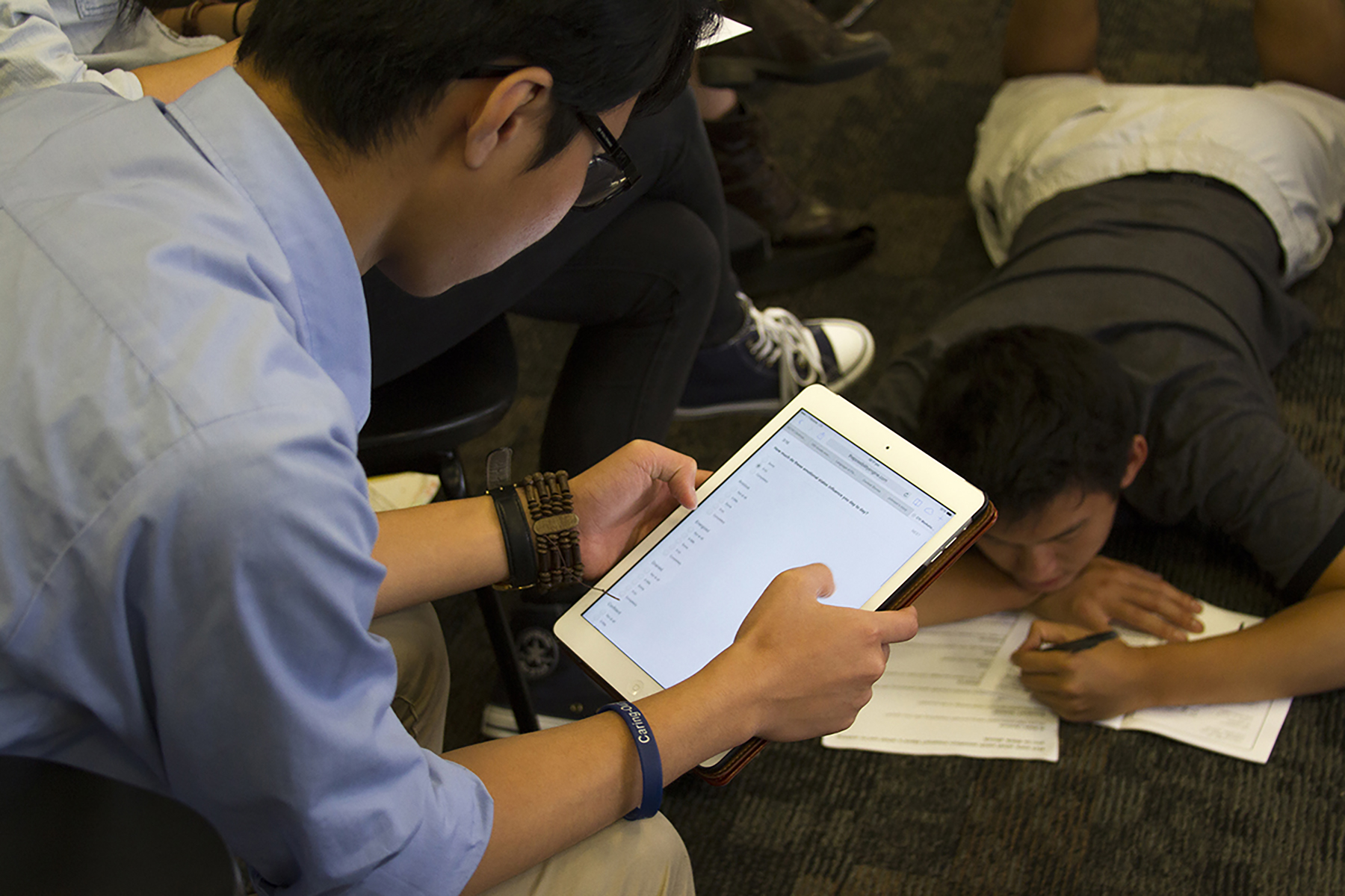 Conference participants filling out paper and digital surveys.