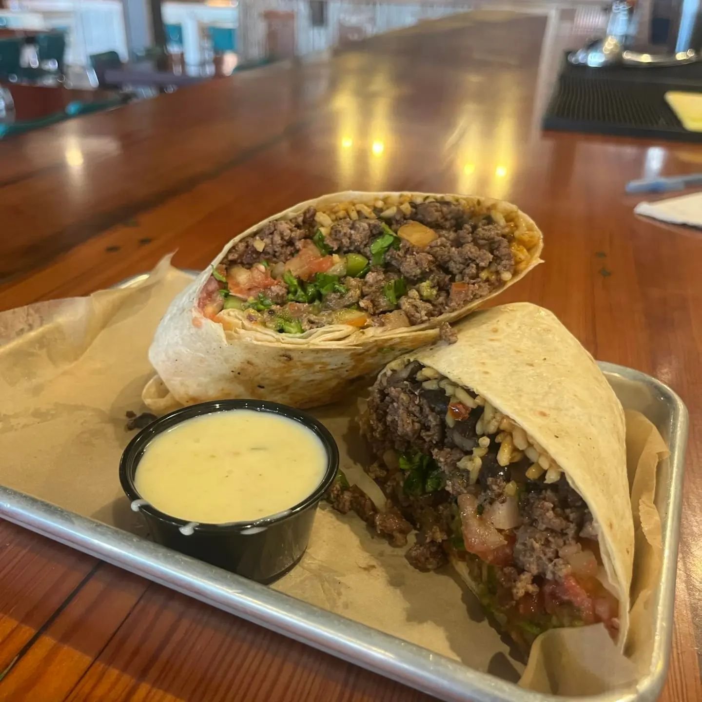 Beef burrito topped with your choice of Spanish rice, black beans, lettuce, tomato, onion, fresh guacamole and salsa all with a side of queso! $6 each