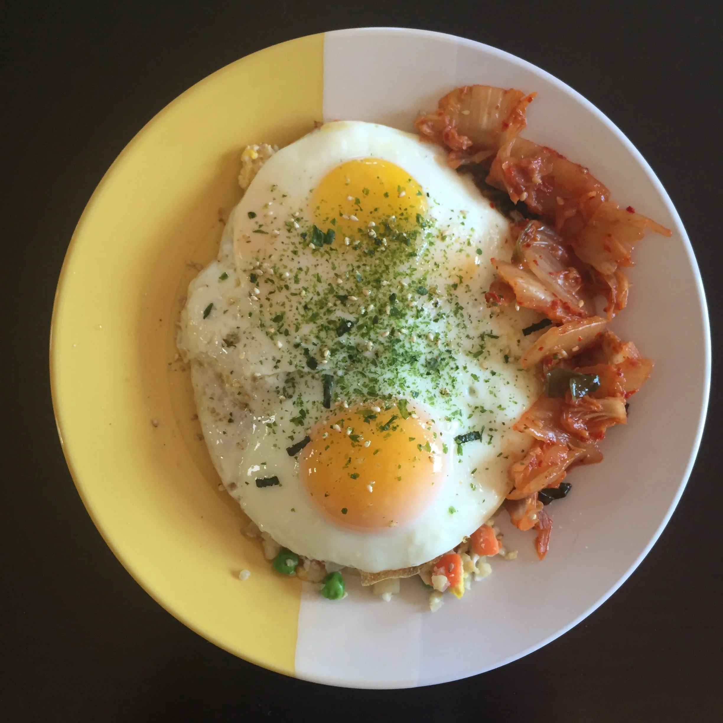  This paleo breakfast bowl is cauilflower fried ‘rice’ on the bottom (you can find some in the freezer aisle), two fried eggs and a side of fermented kimchi (spicy korean cabbage and veggies that are easy to digest and good for your gut microbiome!) 