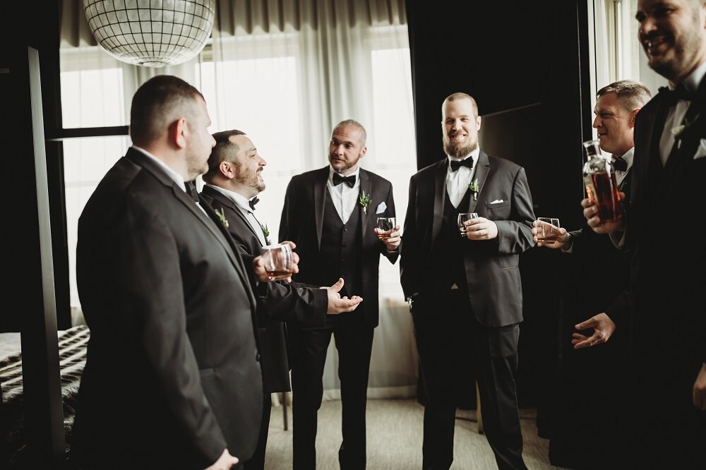 groom and groomsmen sharing a drink in a hotel