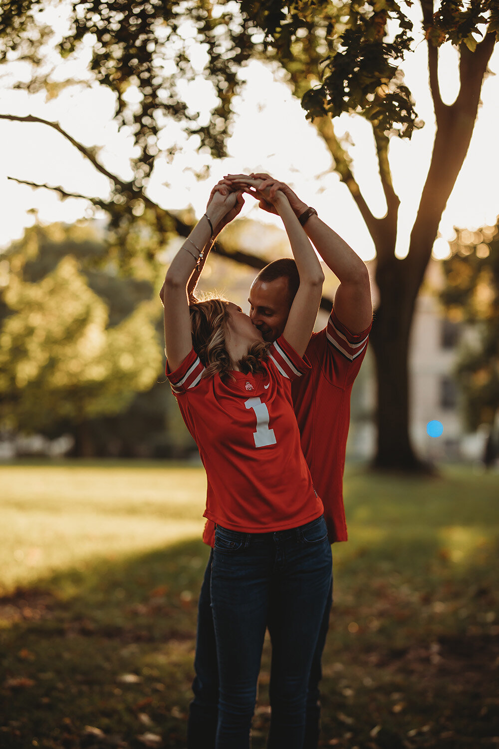 Engagement portraits of couple wearing ohio state university jerseys.