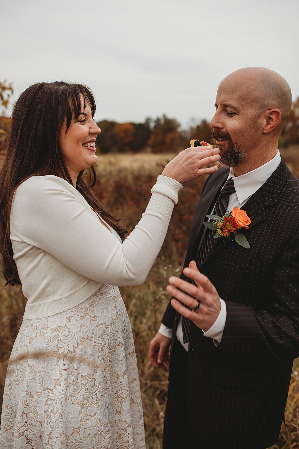 bride feeds groom a piece of cake