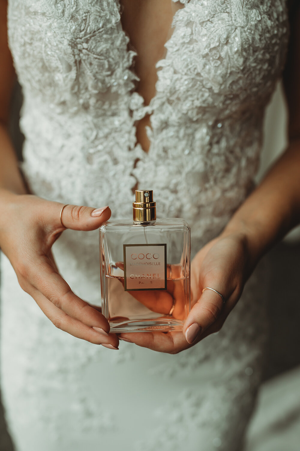 bride holding bottle of perfume 