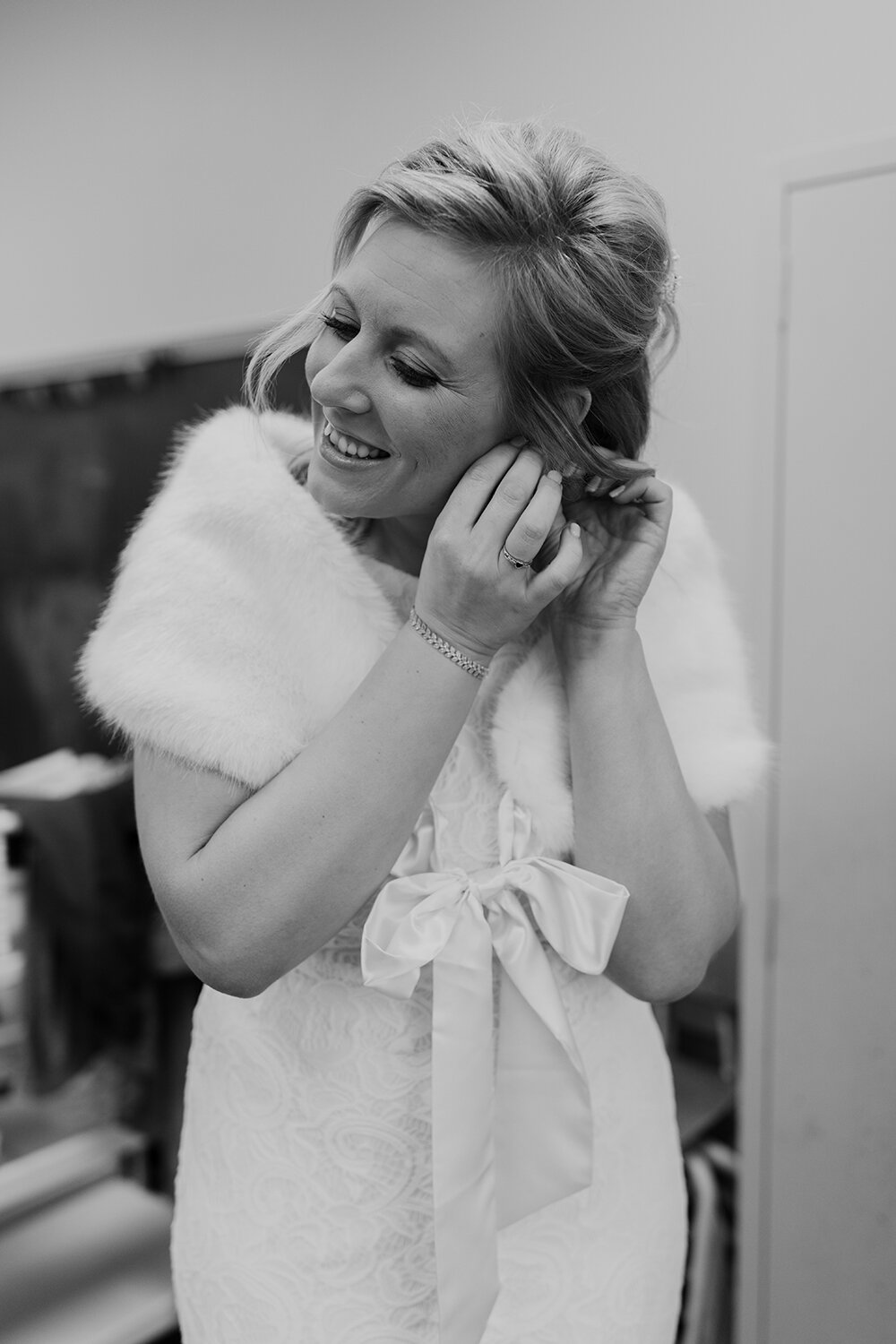 bride putting on earrings 