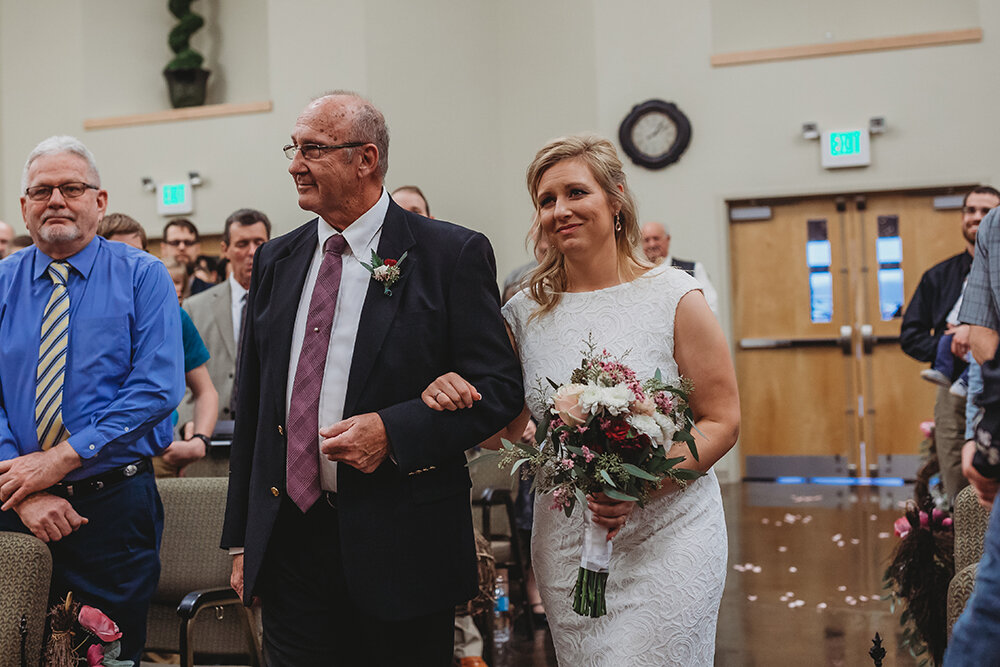 bride walking down the aisle with father 