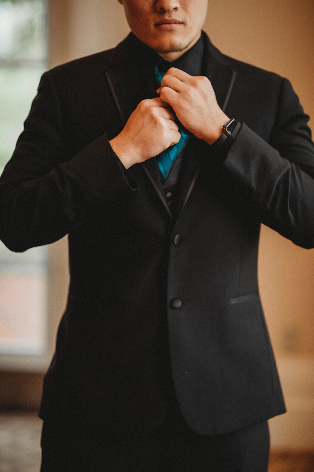 groom adjusting his tie 