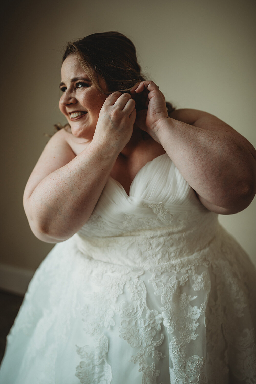 bride putting on earrings 