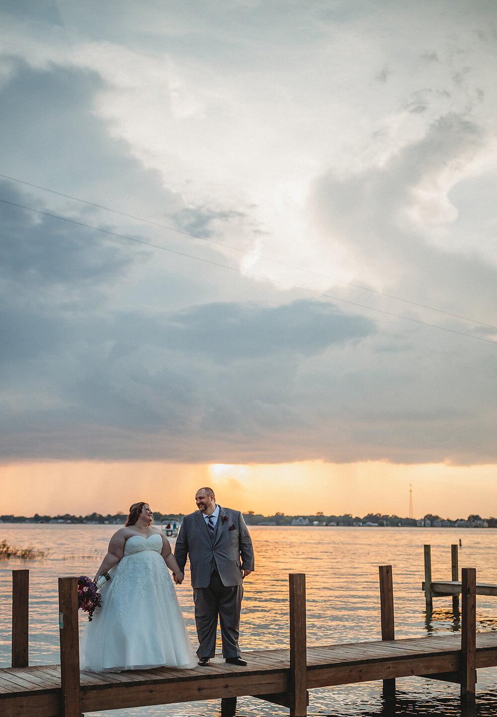 bride and groom by the lake dock