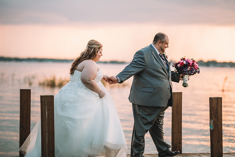 bride and groom by the lake dock