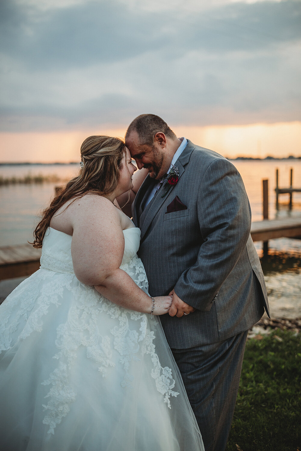 bride and groom by the lake dock