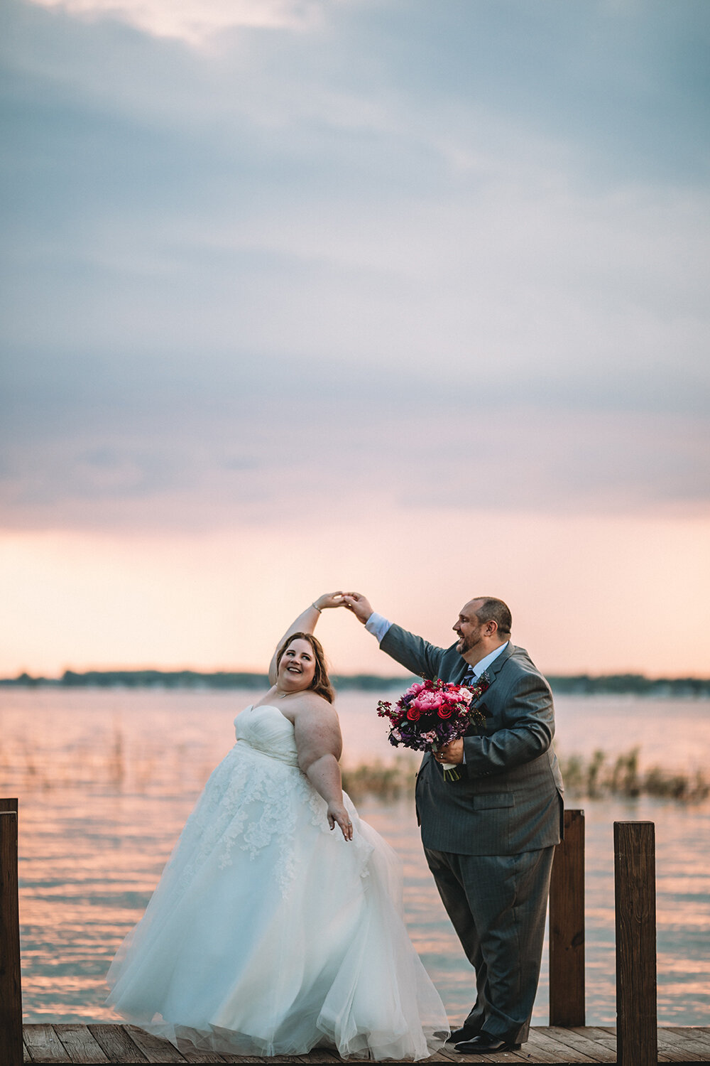 bride and groom by the lake dock
