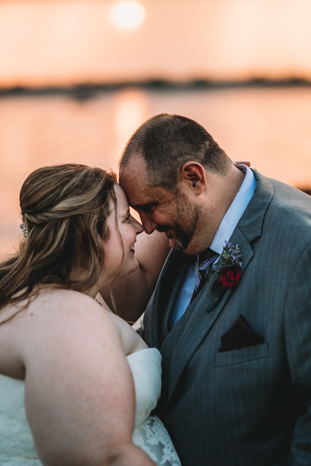 bride and groom by the lake dock