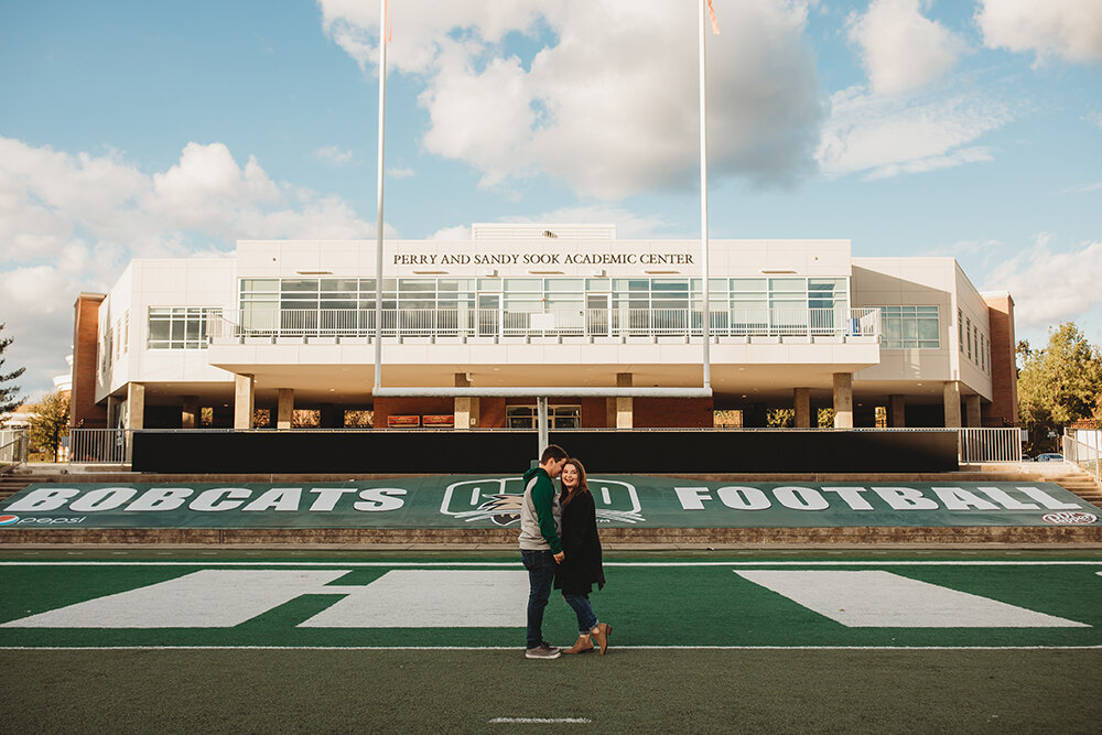 couple portraits on football field 