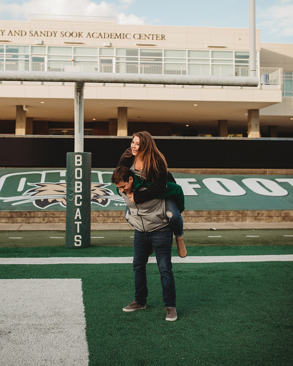 couple portraits on football field 