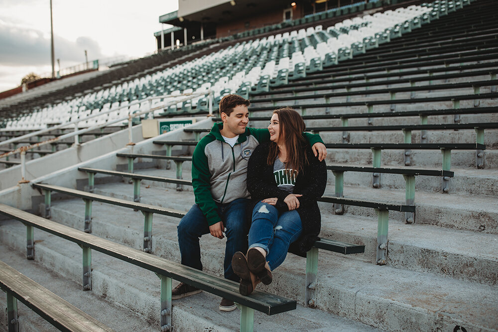 couple sitting in the football stands 