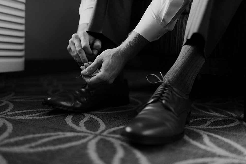 groom putting shoes on 