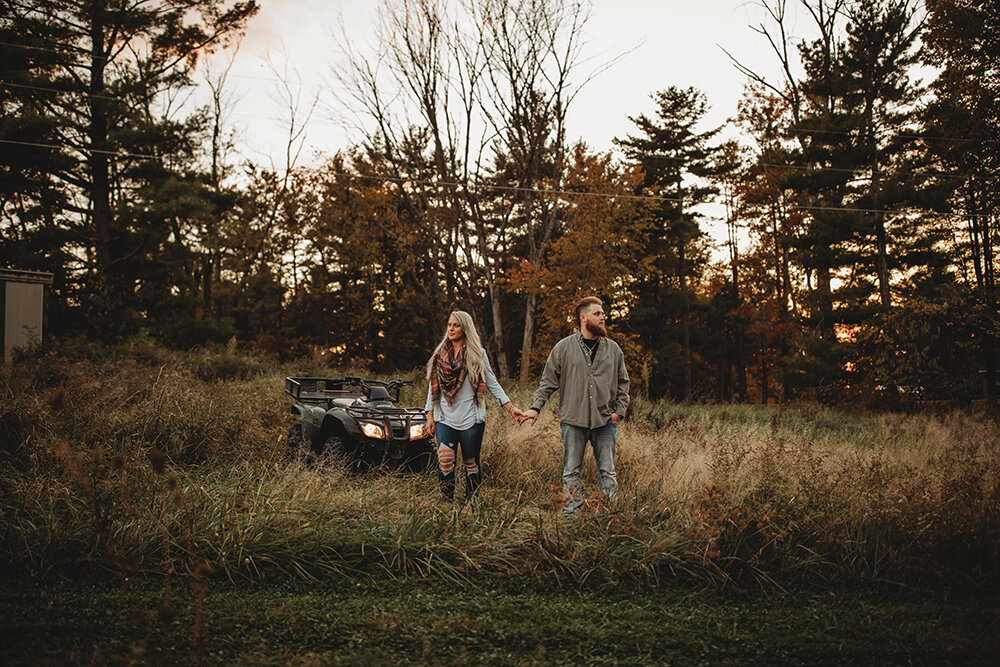 couple stand in front of atv 