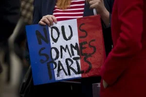 A woman holds a French flag colored placard with French translating as "we are Paris" whilst attending a vigil for victims of the deadly Paris attacks, in Trafalgar Square, London, Saturday, Nov. 14, 2015. French President Francois Hollande said more than 120 people died Friday night in shootings at Paris cafes, suicide bombings near France's national stadium and a hostage-taking slaughter inside a concert hall. (AP Photo/Matt Dunham)/LMD124/263092334897/1511141544