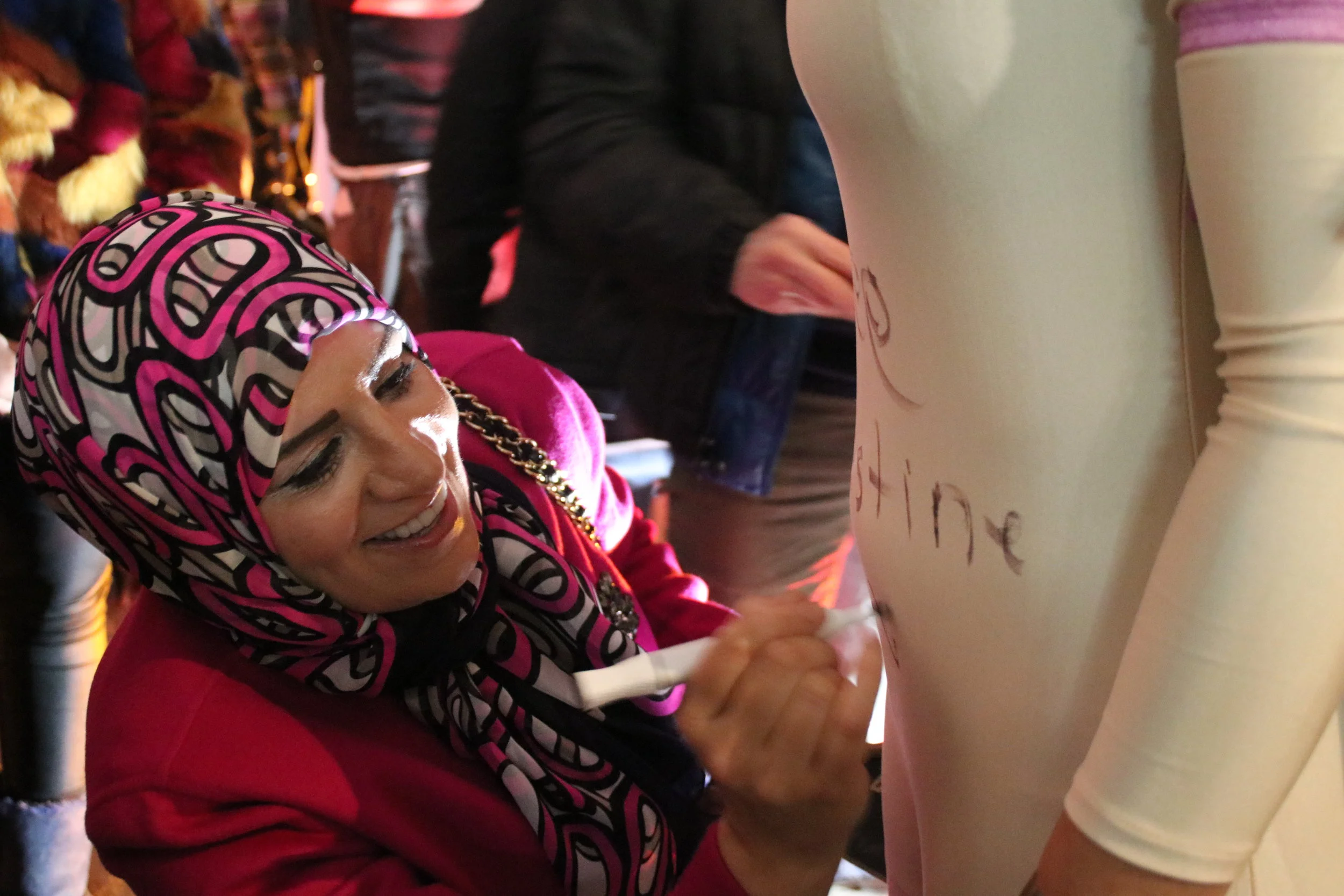  Artist Quinza Najm executed an interactive statement art piece, where she asked women of all ages, colors, shapes, and sizes to wear flesh leotards and to sport hijabs. After the show, she asked the audience to write messages on her models' attire.&