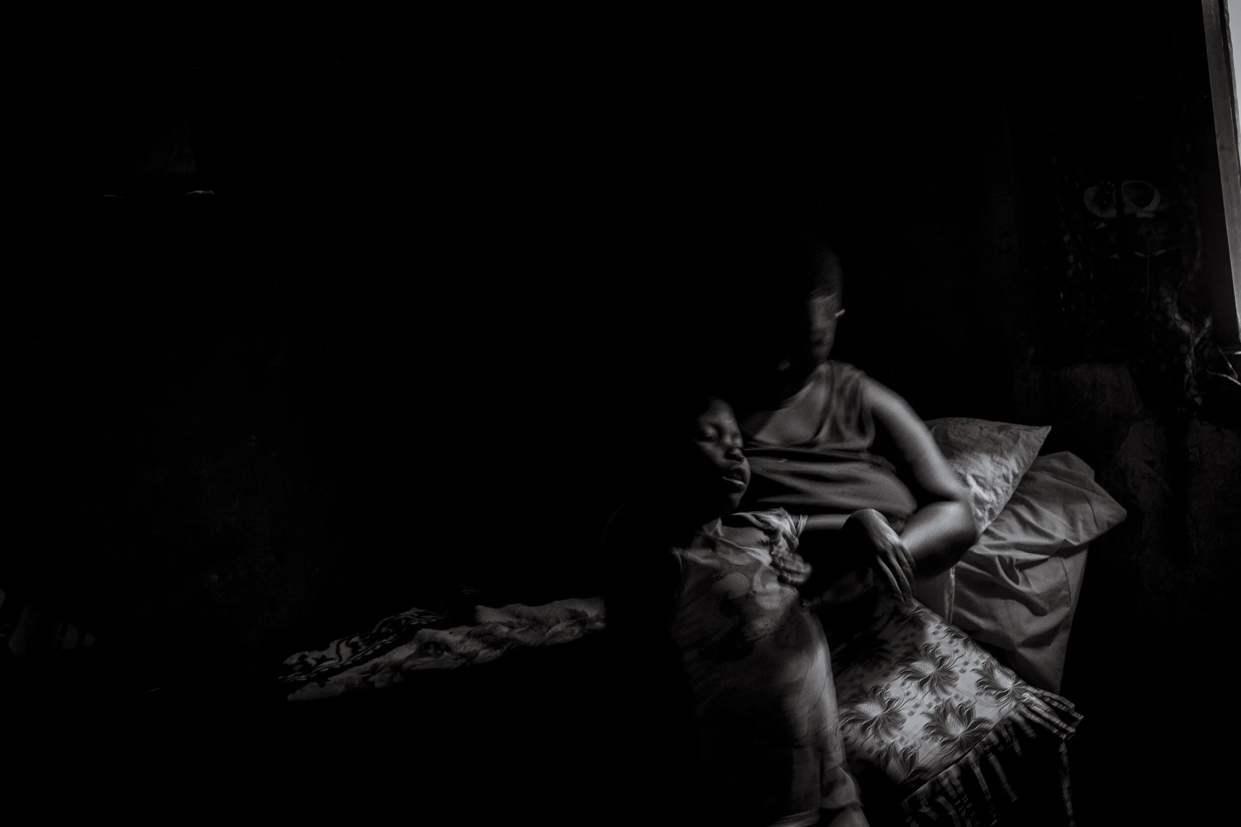  Lugonjo, Uganda. Nono Zubeda picks up her 9-year old daughter Salma Kobusinge as she falls over in their two bedroom Entebbe home. The falls are common as Salma  lives with an intellectual impairment, believed to be low functioning Autism.  