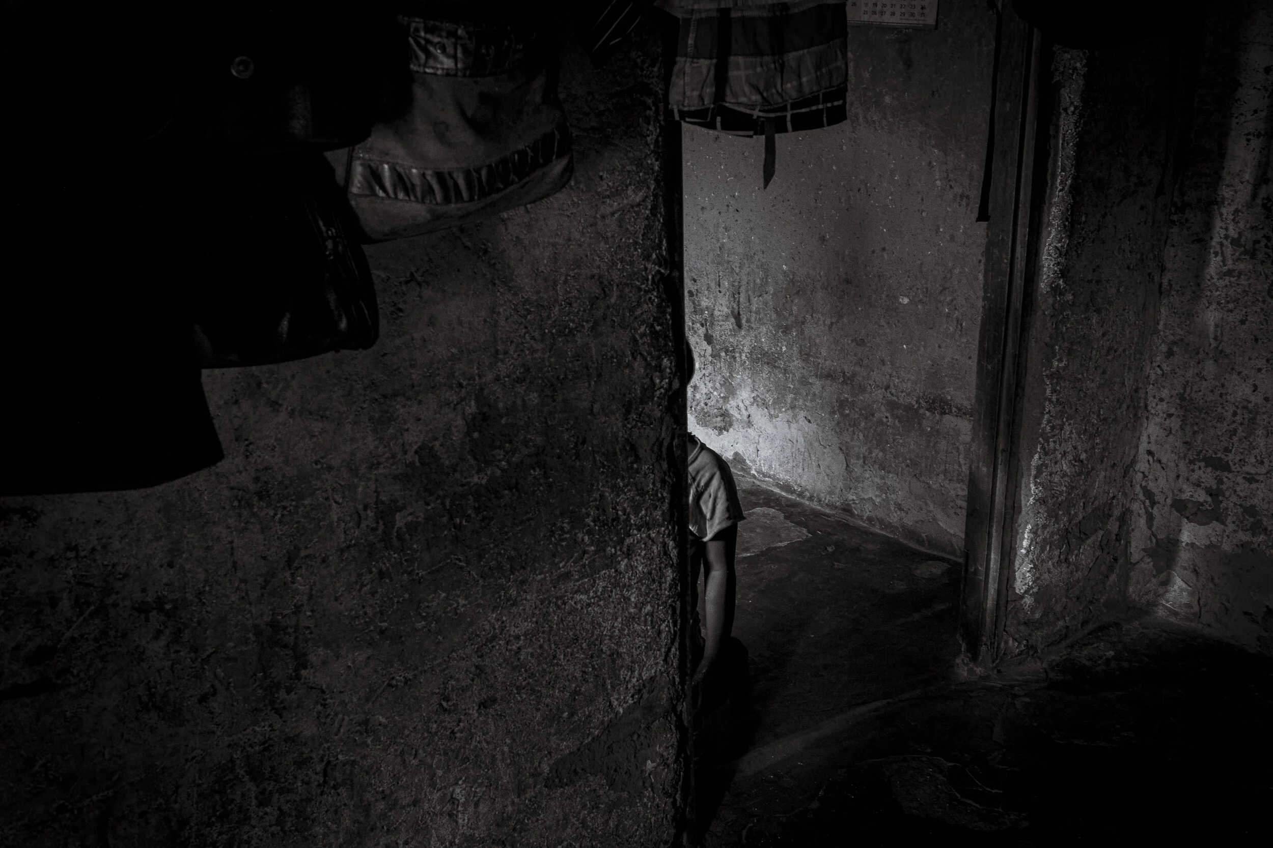  Lugonjo, Uganda. Salma Kobusinge kneels alone in her Entebbe home. 9-year old Salma lives with Autism. She does not speak, has Epilepsy, Sickle cells, is deaf and blind in her right eye. Her mother, Nono Zubeda has told disability outreach worker St