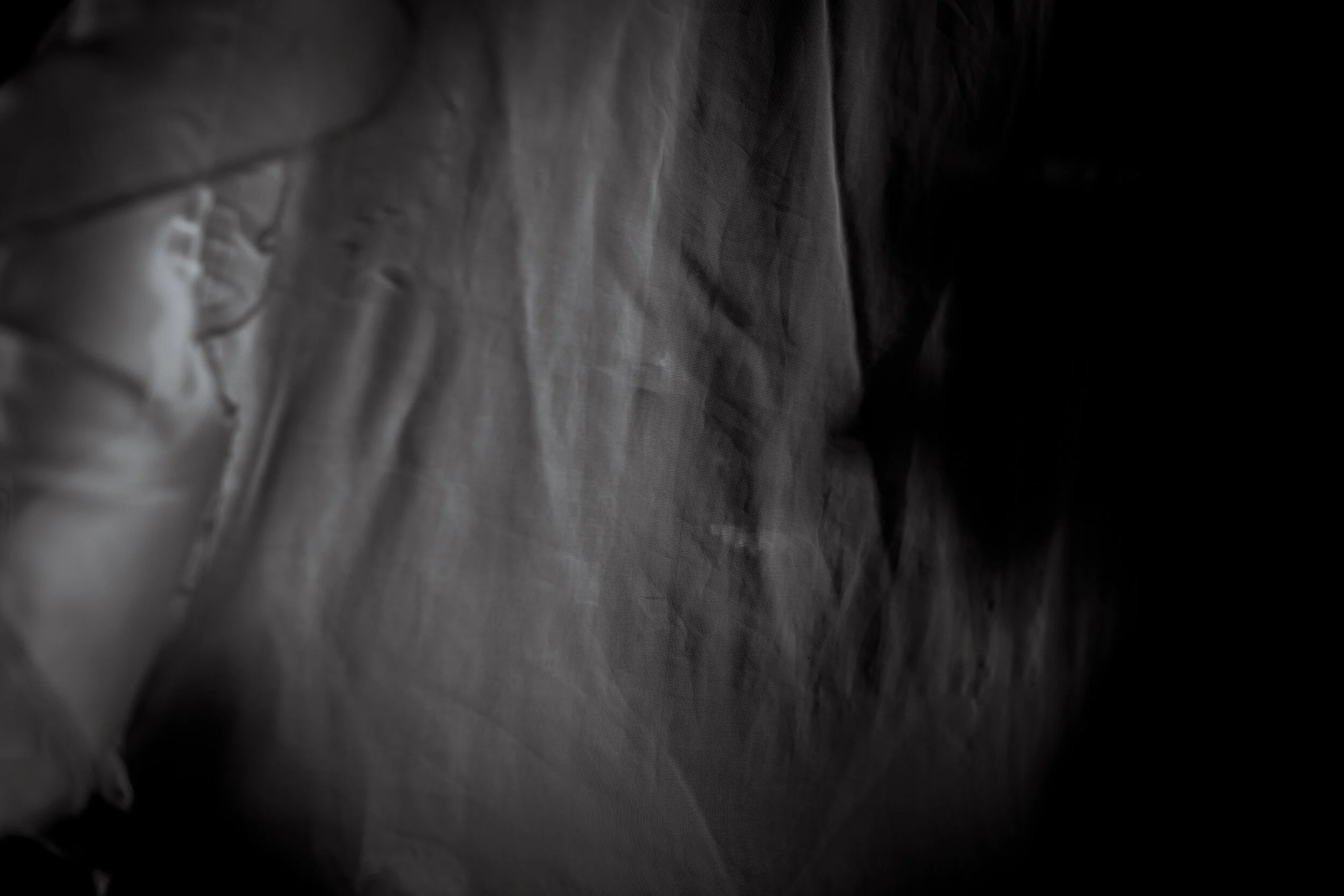  Gulu, Uganda. Grace hides behind some mosquito netting at her home. Symbolic of how trauma affect’s central Africans, Grace never managed a smile, until she hid behind a piece of netting at her home. She now attends the Living Hope program, which pr