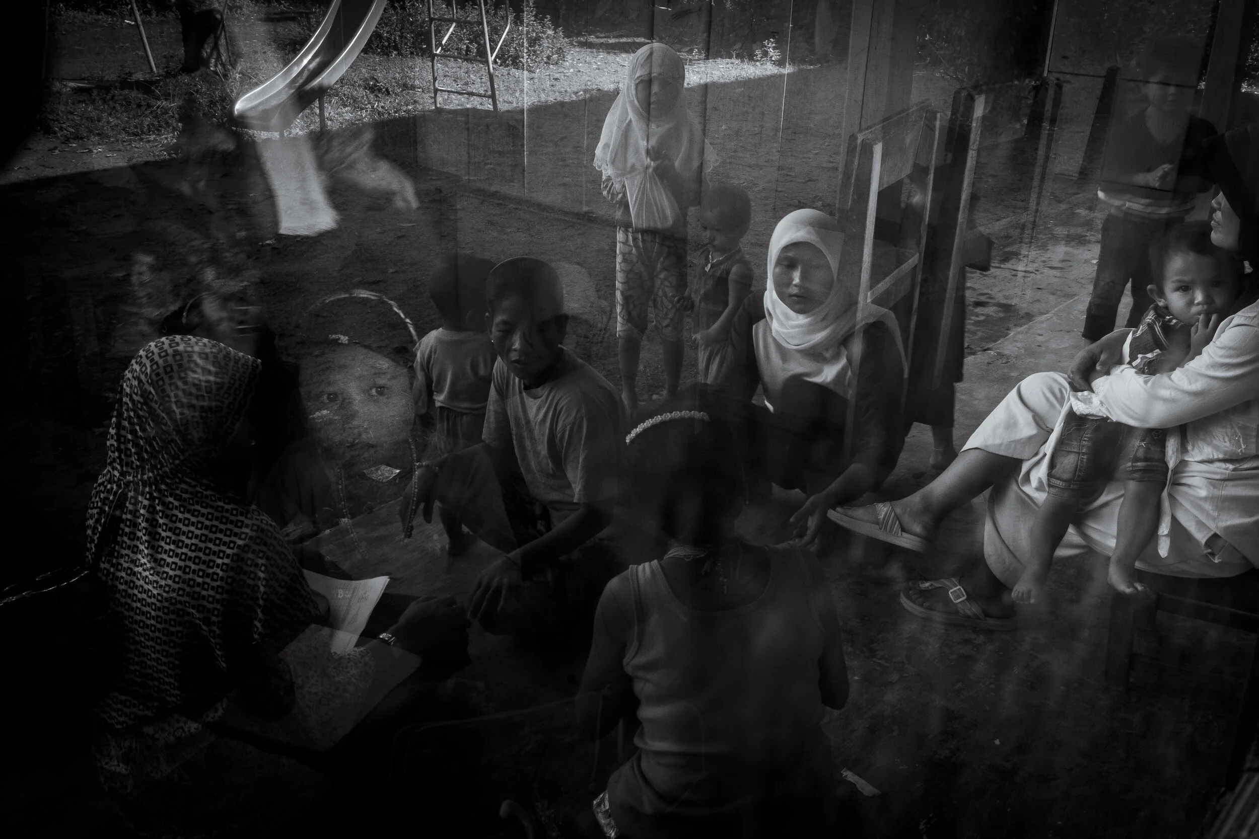  Masit Dere's daughter Ukan (6) stares through the window at the Islamic government school she attends with her brother Pandin in Matatonan. Her parents receive financial benefits for sending the two children to school and it is illegal for children 