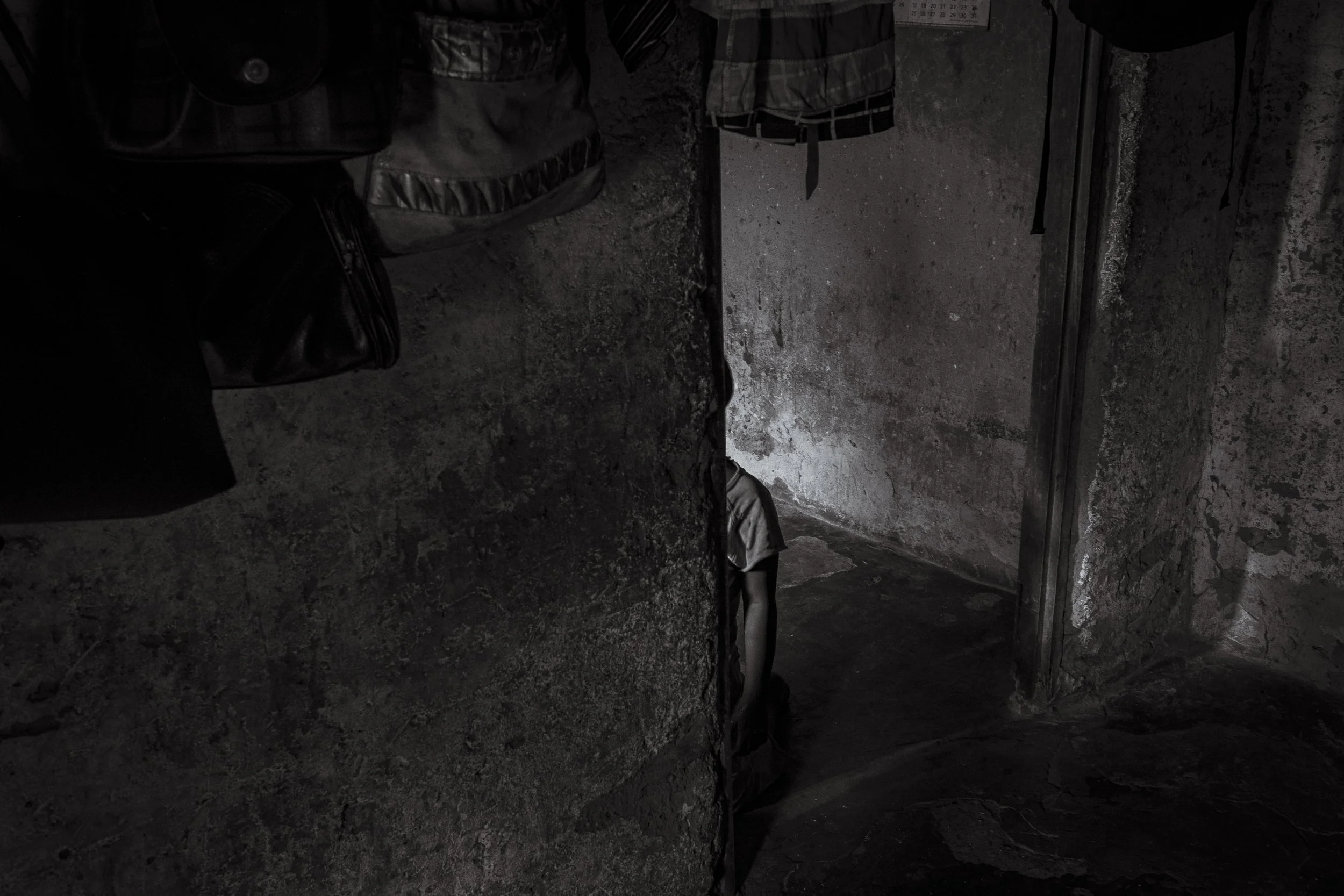  25 February 2020. Lugonjo, Uganda. Salma Kobusinge kneels alone in her Entebbe home. 9-year old Salma lives with Autism. She does not speak, has Epilepsy, Sickle cells, is deaf and blind in her right eye. Her mother, Nono Zubeda has told disability 
