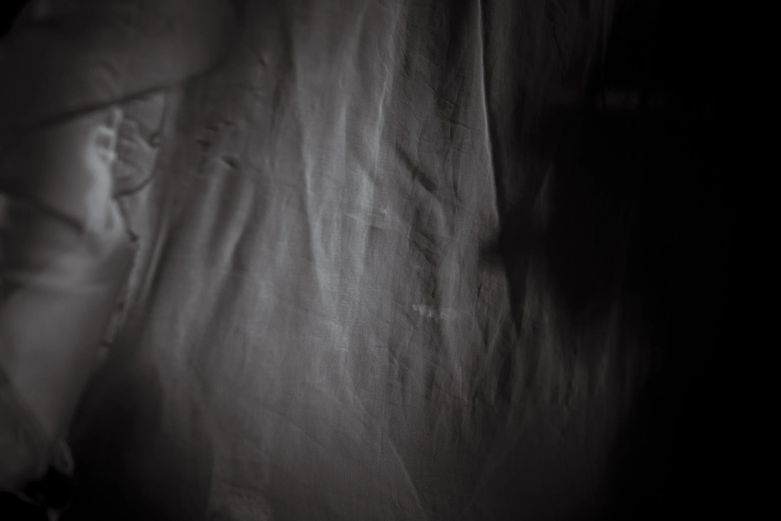  19 November 2014. Gulu, Uganda. Former Lords Resistance Army (LRA) abductee Grace Aviro smiles whilst hidden behind a mosquito net.  Grace Aviro was abducted by the Joseph Kony led LRA and spent 14 years in the bush. Beaten, tortured and raped she w