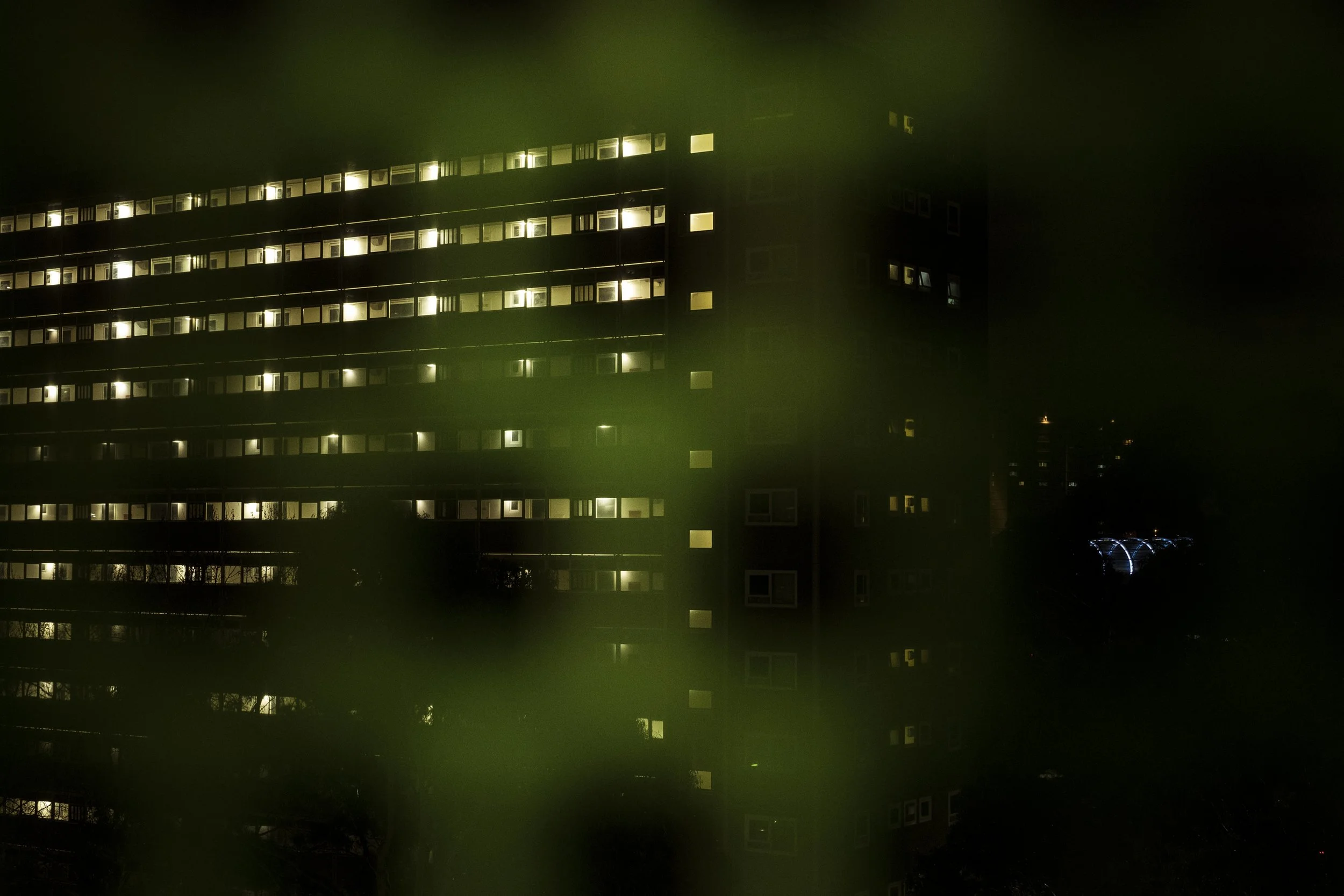  25 June 2021, Alfred Street, North Melbourne, Australia. The Alfred Street public housing towers, illuminated by the apartments front door lamps, are seen at night from Barry Berih's floor.  