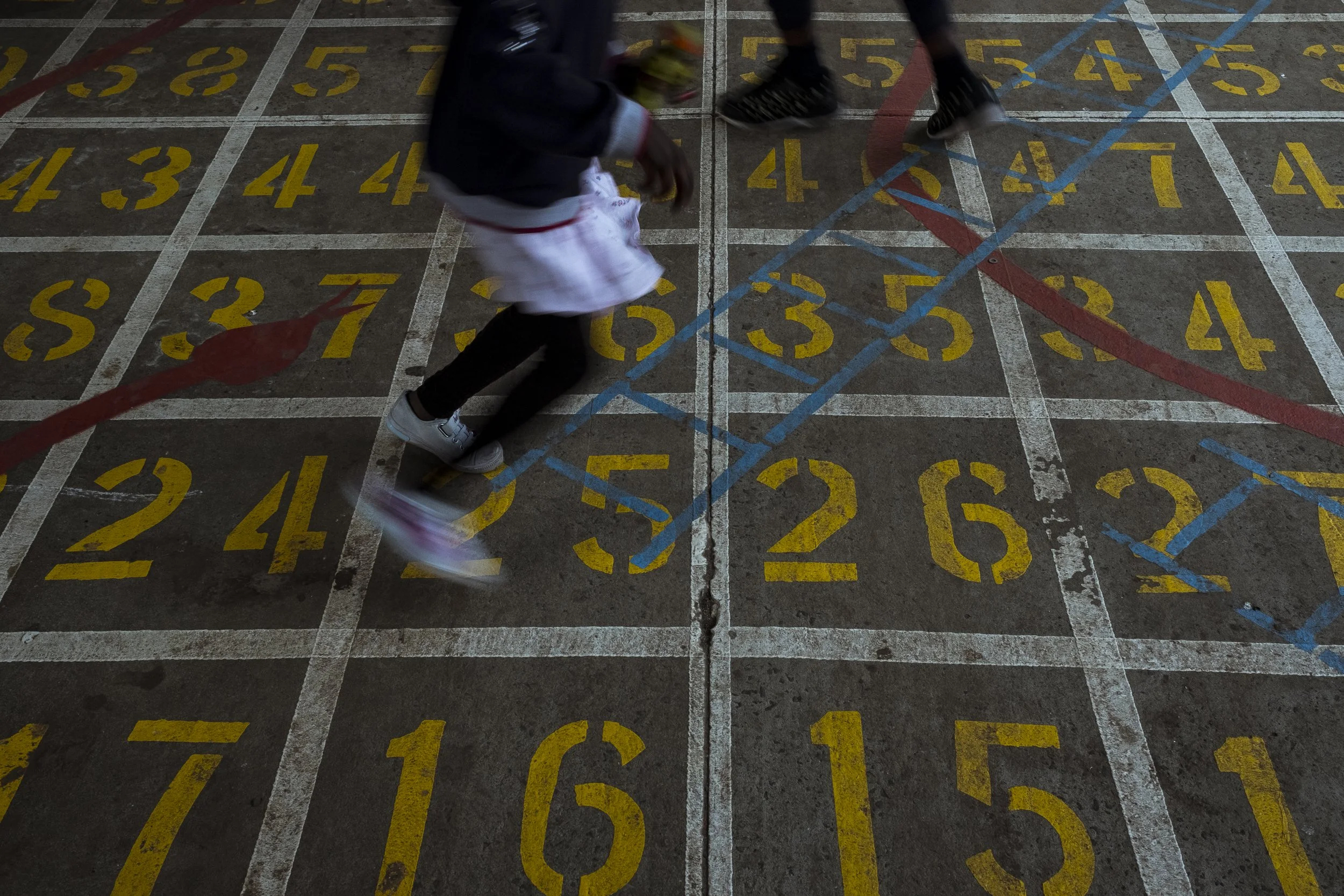  9 July 2020. Wellington Street, Collingwood, Australia. Children play on a snakes and ladders board painted on concrete at the Collingwood housing towers.   “The parks were pristine. I remember hanging on the monkey bars, and the scenes through the 