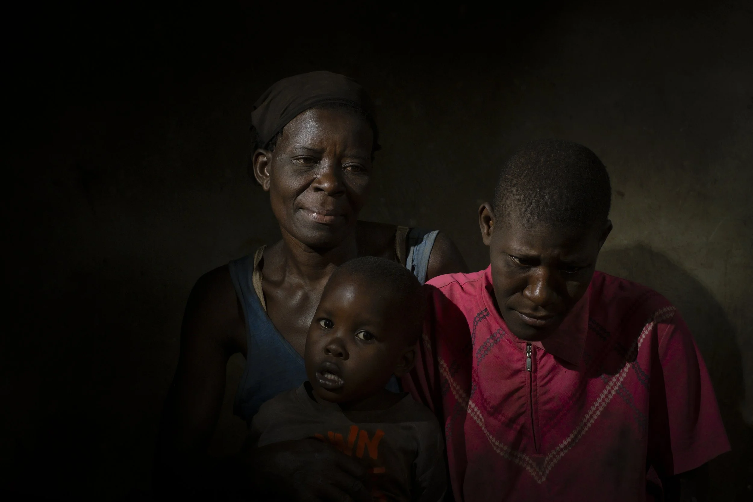  Namazala, Jinja District. Katherine Muwunguzi, her mother Joy Nangobi and her son Edwin Musasizi. 20-year-old 'Kat' was raped repeatedly by a neighbour at a young age resulting in the pregnancy and birth of a son - Edwin - four years ago. Kat lives 