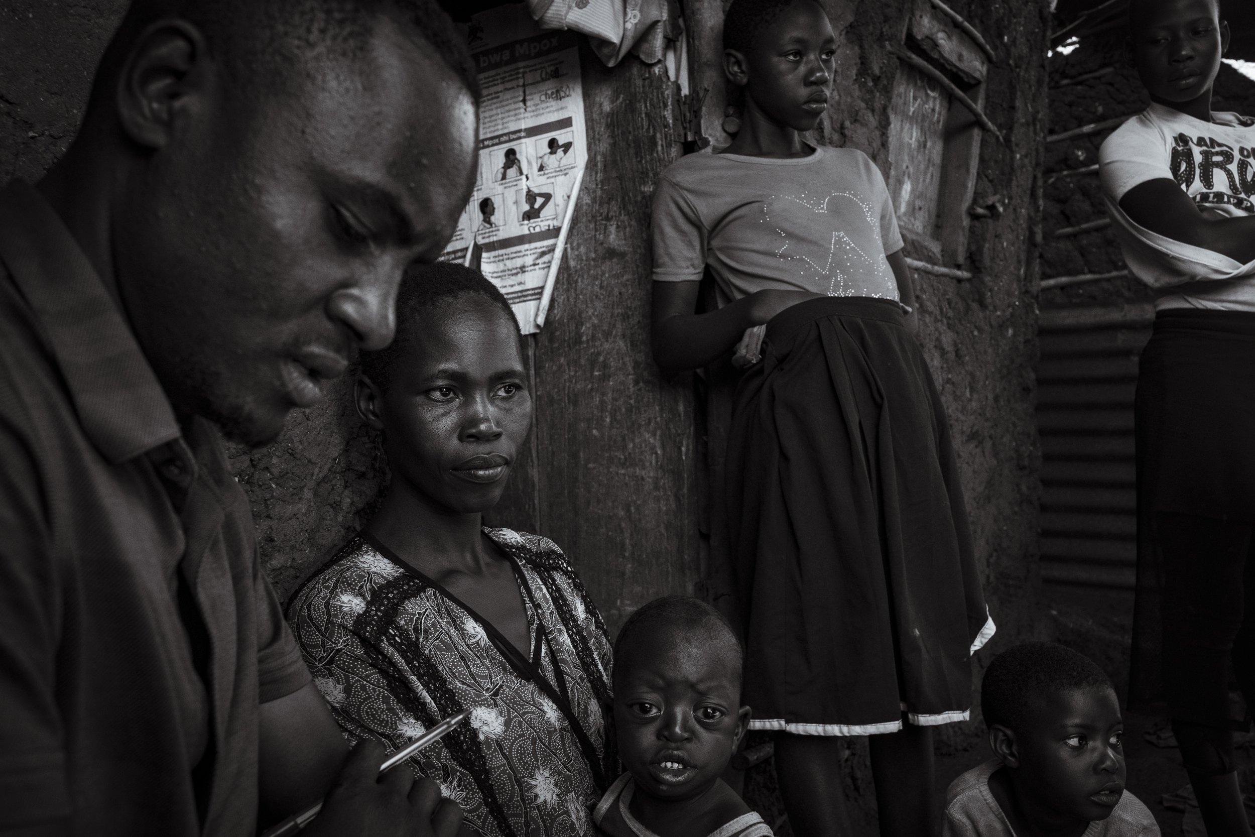  25 November 2024. Wanyange, Uganda. Near the shore of Lake Victoria social worker Stephan Kigozi conducts an outreach meeting with Olivia Mugala. Olivia's four-year-old son  James Mugabe lives with Down Syndrome. As a result of her husband abandonin