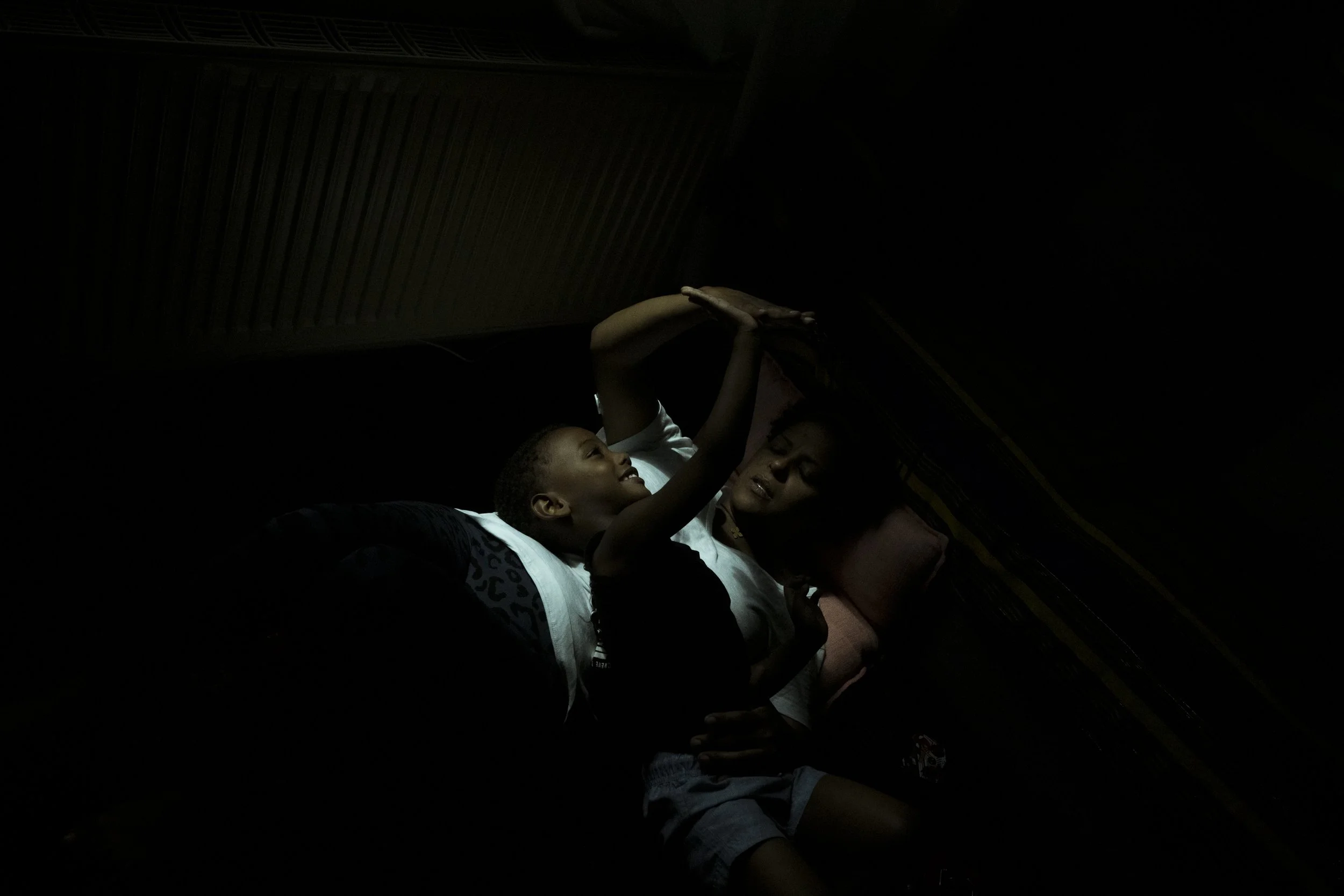  18 November 2024. 126 Racecourse Road, Flemington, Australia. Single mother Bezawit Gizaw relaxes in the morning light with her son Yabsera. 'Beza' emigrated to Australia in 1996 from Ethiopia and immediately lived in public housing with her father.