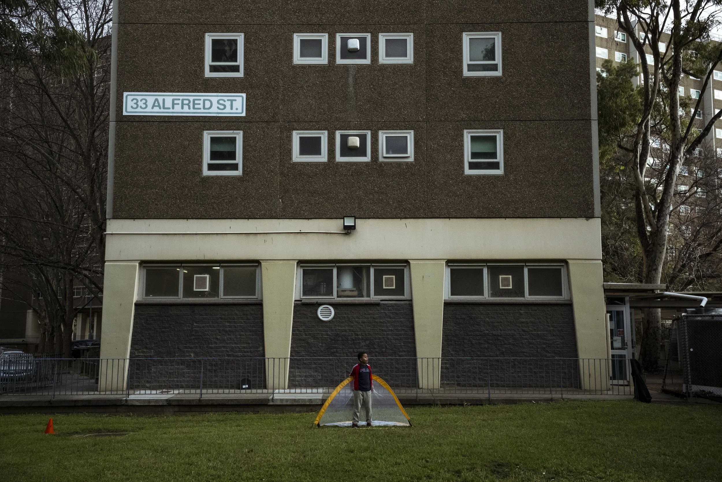  22 June 2024. 33 Alfred Street, North Melbourne, Australia. At a local celebration for Eid, a young member of the local Somali community stands in goal during a local footbal match between residents of the North Melbourne Public Housing estate. 