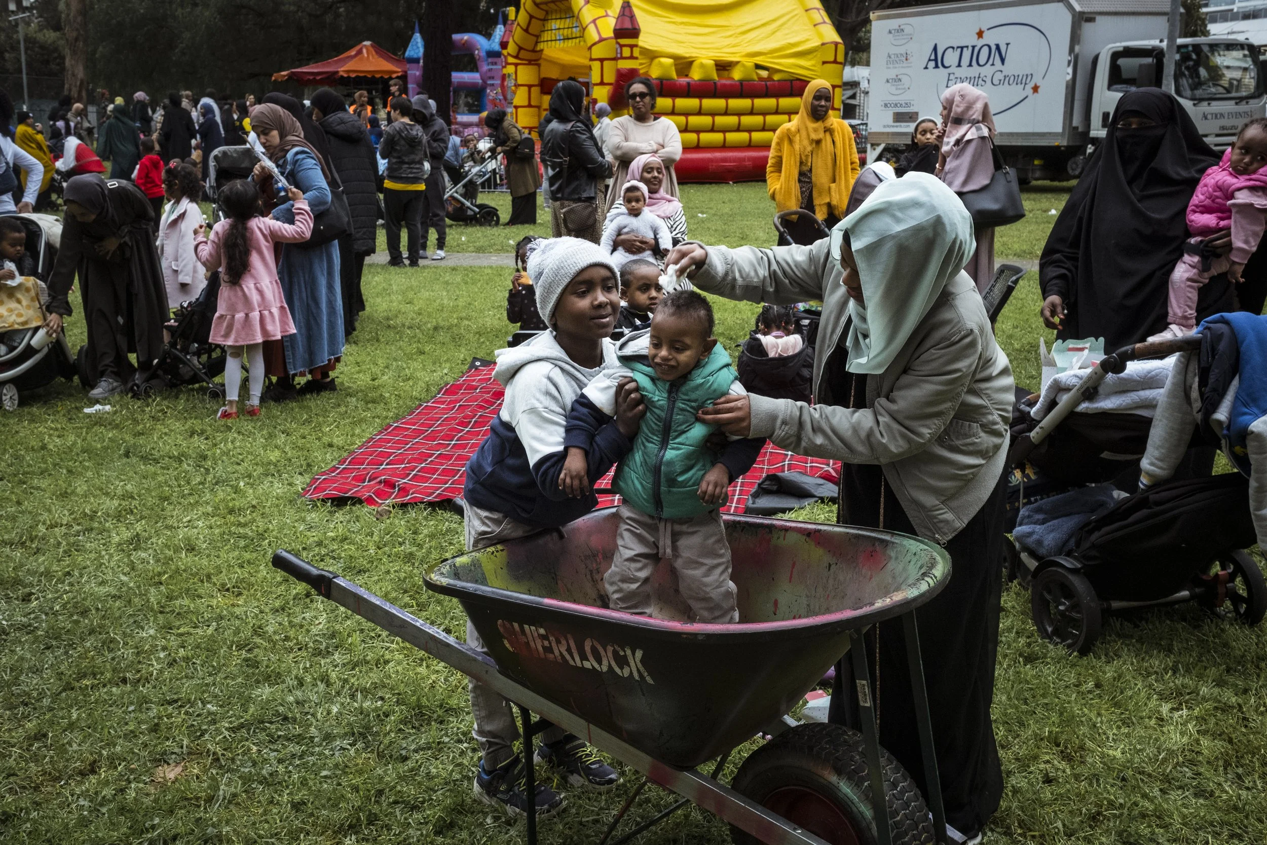  22 June 2024. 33 Alfred Street, North Melbourne, Australia. Young public housing residents play in a wheelbarrow at a celebration for Eid organised by the local Melbourne Somali Community group.   Tightly knit diaspora communities will be hard hit b