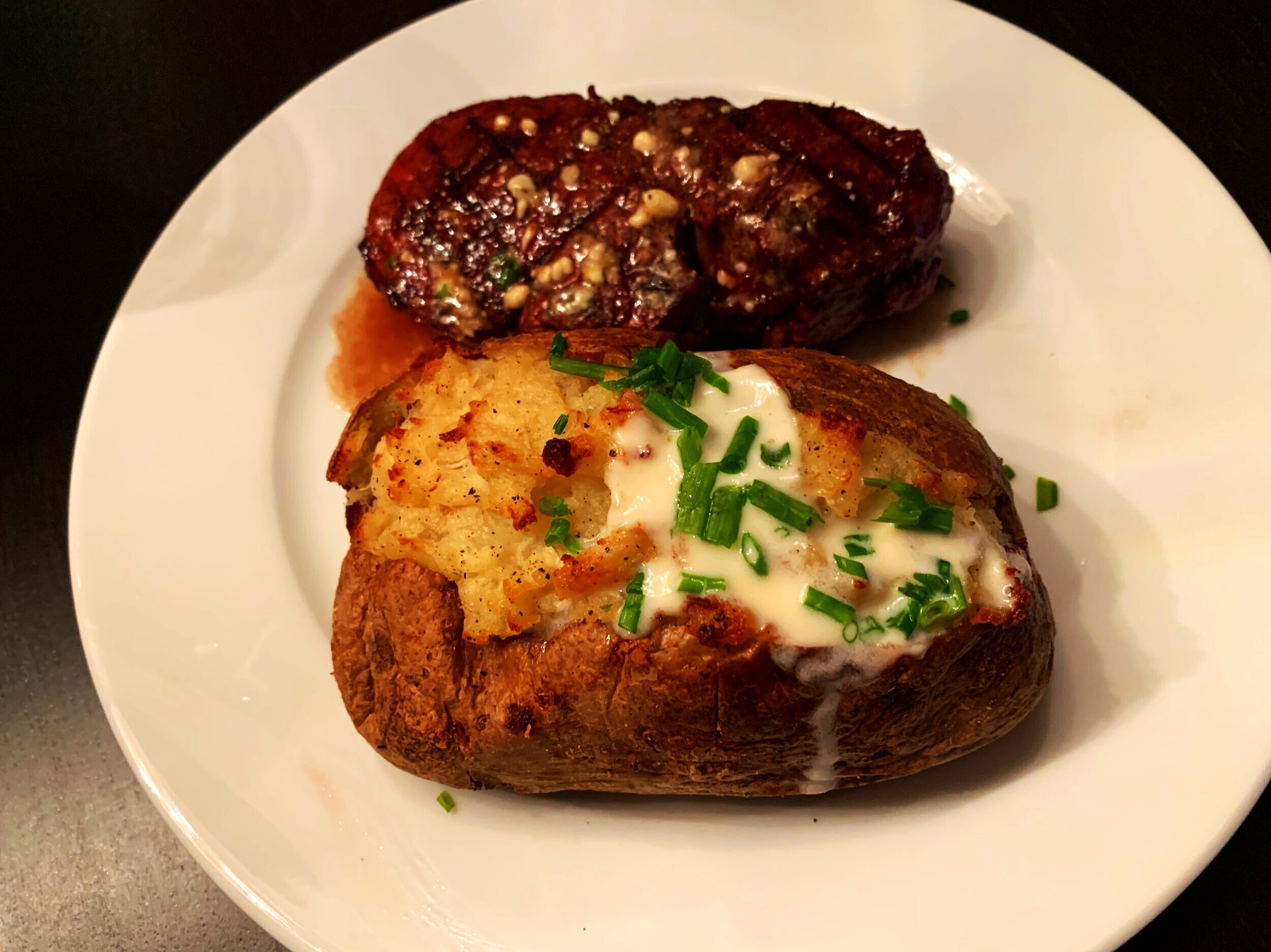 Crab-stuffed baked potato &amp; steak with compound blue cheese butter
