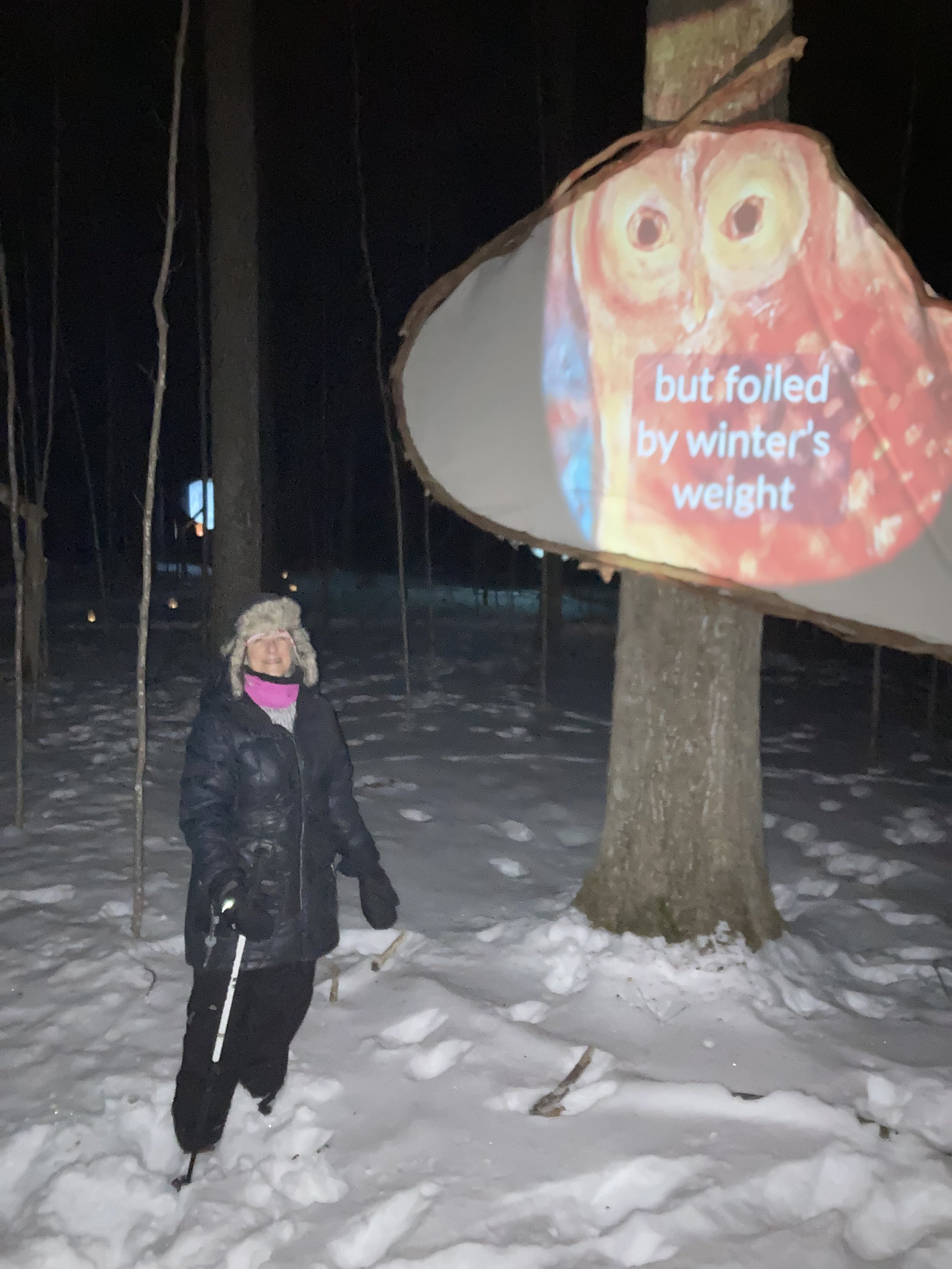 Candelin Wahl beside her illuminated, illustrated owl poem "Camouflage."