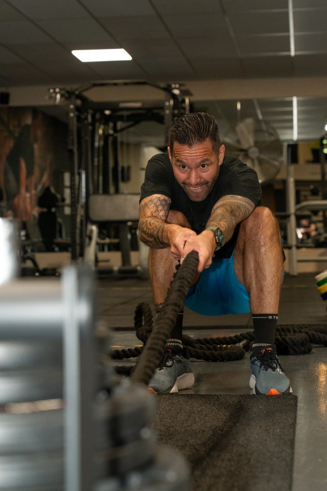Man doet een krachttraining met touw in de sportschool.