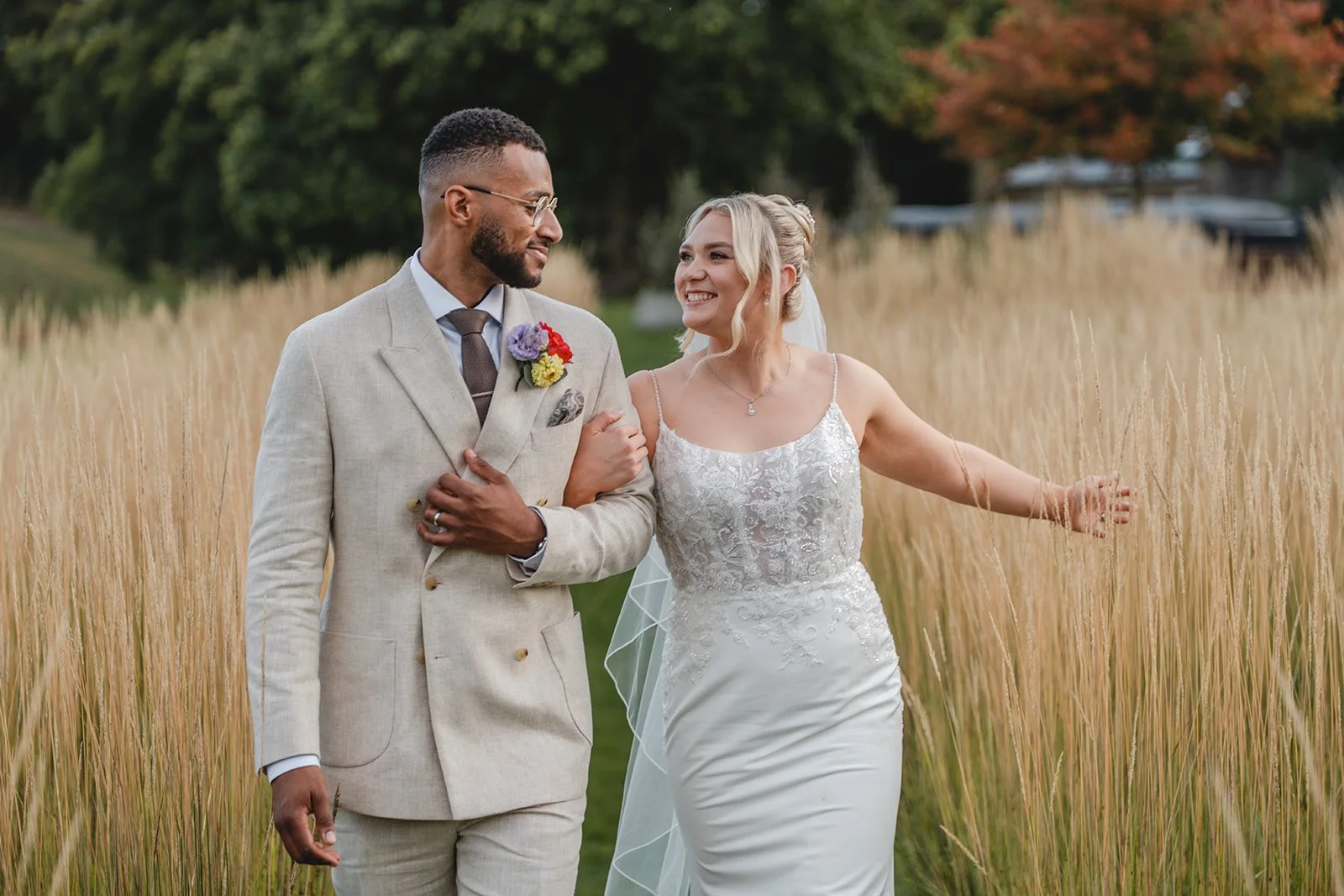 Kirsten and Josh walking together through tall grass