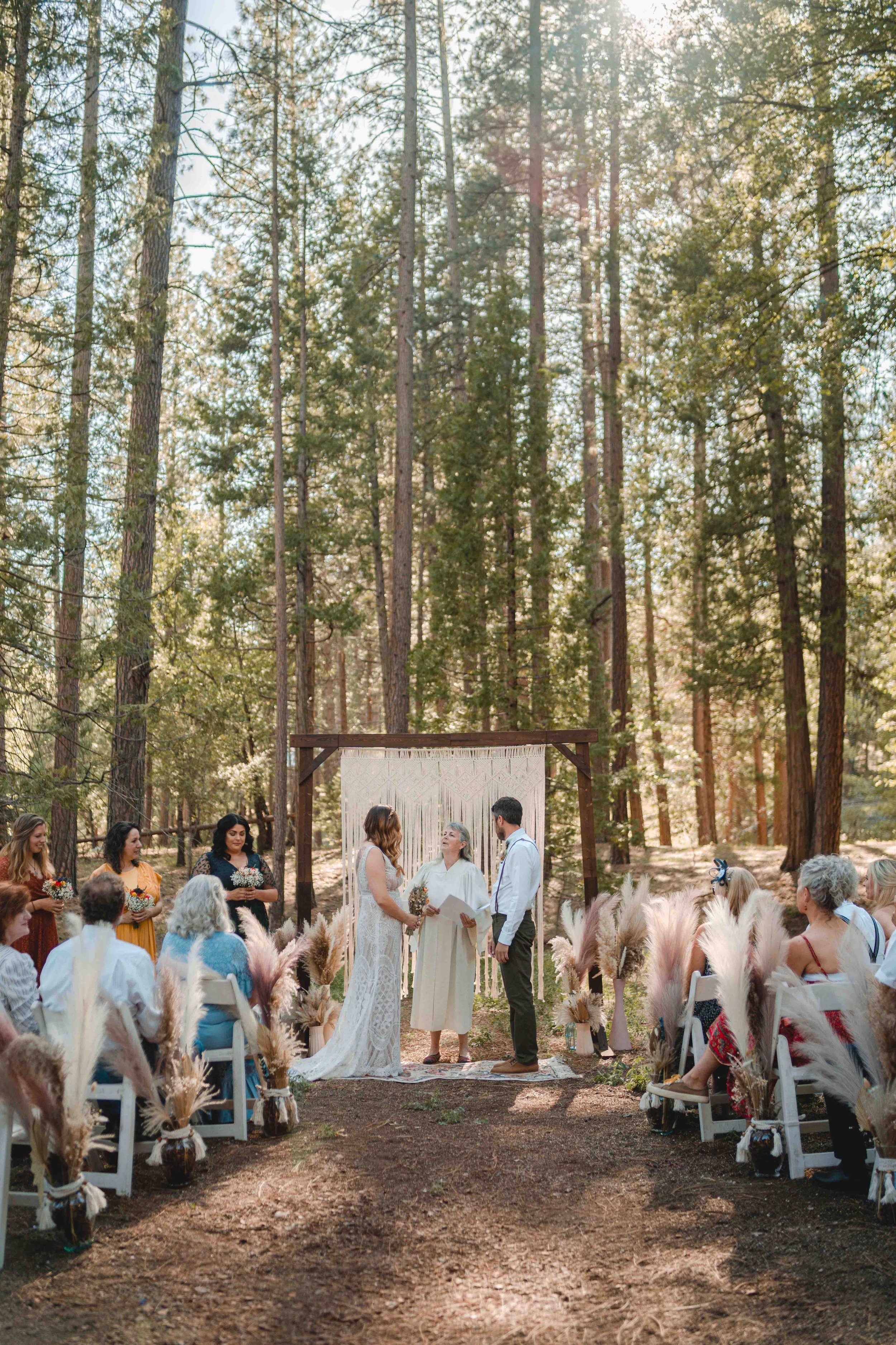 The couple holding hands at the end of the aisle
