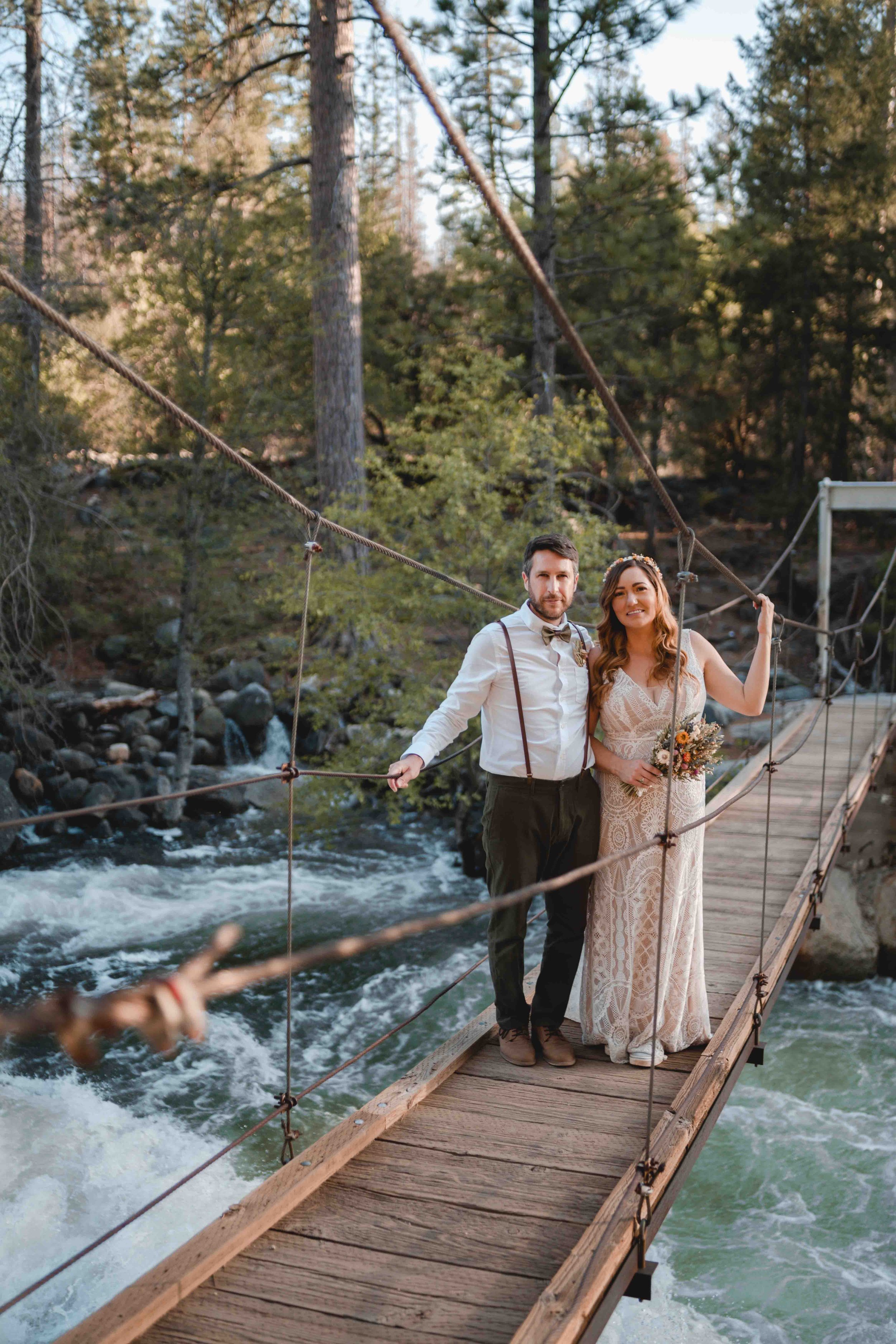 Newly weds standing on a bridge at sunset