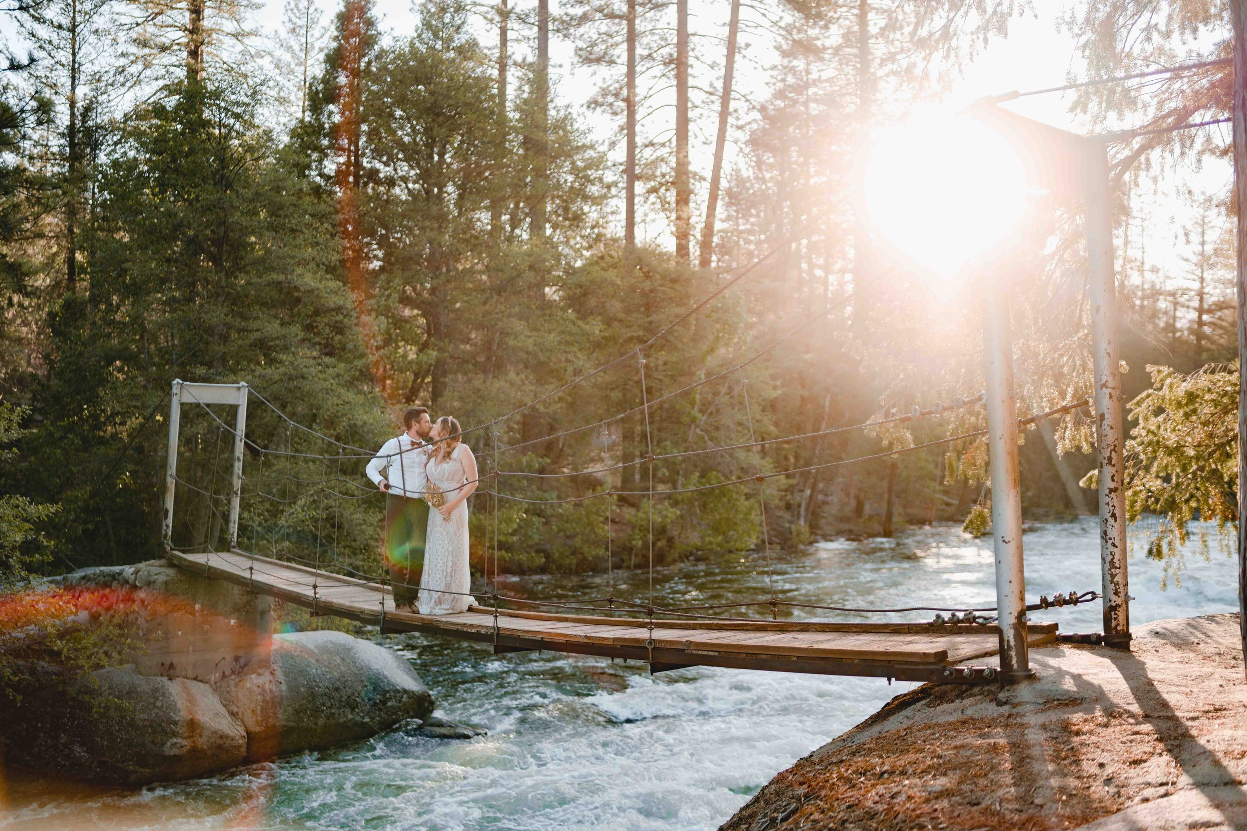 Newly weds standing on a bridge at sunset